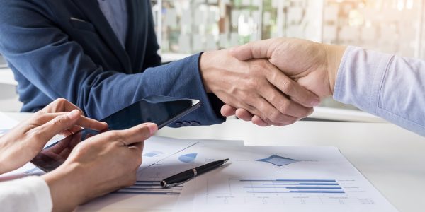 Business handshake of two men demonstrating their agreement to sign agreement or contract between their firms, companies, enterprises